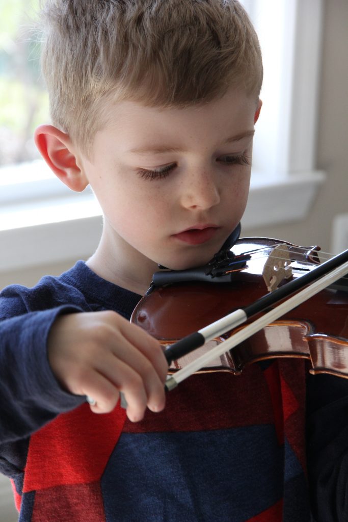 Aidan tries his new violin for the first time. 